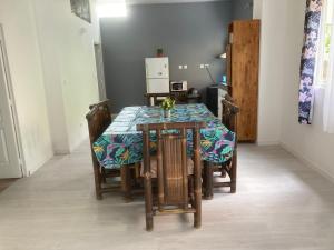 une table à manger et des chaises avec un chiffon bleu et vert dans l'établissement bungalow les cases près de la Mare à joncs, à Cilaos