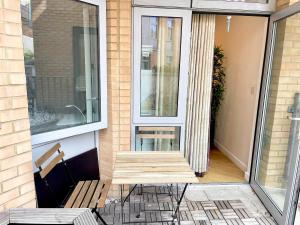 a screened in porch with a bench and a window at Modern Patio Flat close to Sation & Canary Wharf in London