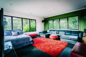 a bedroom with a bed and a couch and a red rug at BELLINGEN CONVERTED CHURCH on the river (Pet Friendly) in Bellingen