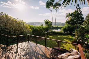 a wooden deck with a table and a chair on it at BELLINGEN CONVERTED CHURCH on the river (Pet Friendly) in Bellingen