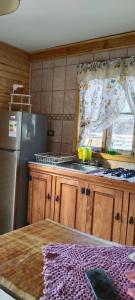 a kitchen with a stainless steel refrigerator and a sink at Cabaña AlaSa in Los Ángeles