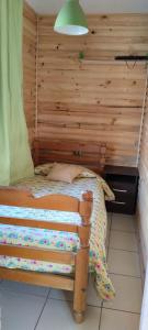 a bedroom with a bed with a wooden wall at Cabaña AlaSa in Los Ángeles