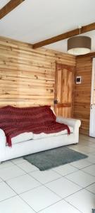 een bed in een kamer met een houten muur bij Cabaña AlaSa in Los Ángeles