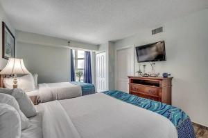 a hotel room with two beds and a flat screen tv at Spectacular Ocean and Coastline Views Condo CB 14th Floor in Myrtle Beach +17 photos