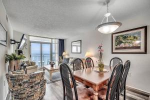 a dining room with a wooden table and chairs at Spectacular Ocean and Coastline Views Condo CB 14th Floor in Myrtle Beach