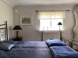 een slaapkamer met een bed met blauwe lakens en een raam bij Holiday home RIMBO III in Rimbo