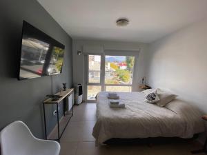 Un dormitorio con una cama grande y una ventana en Lofts Patagonia en San Carlos de Bariloche