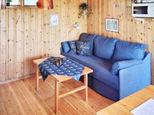 a blue couch in a living room with a table at Holiday home RÄTTVIK in Rättvik