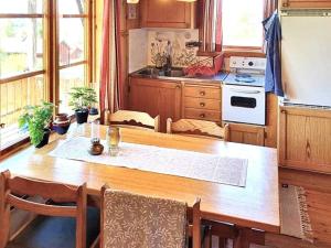 uma cozinha com uma mesa de madeira e uma cozinha com um fogão em Holiday home RÄTTVIK em Rättvik