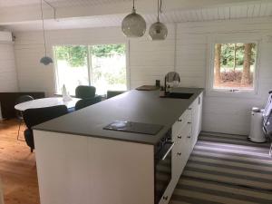 a kitchen with white cabinets and a black counter top at Holiday home Gedsted III in Gedsted
