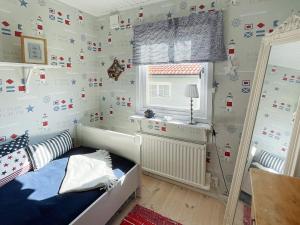 a childs bedroom with a bed and a window at Spacious Family Cottage in Kyrkesund in Skärhamn +24 photos