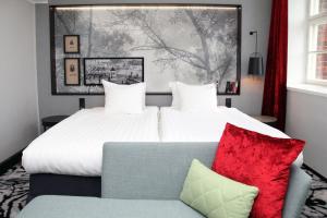 a bedroom with a large bed and a couch at Home Hotel Katajanokka in Helsinki