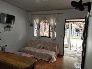 a living room with a couch and a tv at Cabañas MaryMar in Necoclí