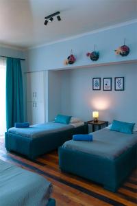 two beds in a room with blue walls at Tagle Casa del Lado Santiago Providencia in Santiago