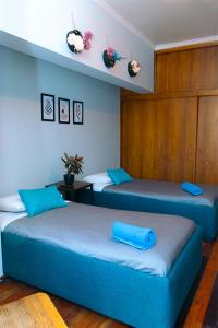 two beds with blue pillows in a room at Tagle Casa del Lado Santiago Providencia in Santiago