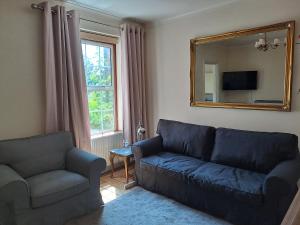 sala de estar con sofá y espejo en Maidenhead House Serviced Accommodation in quiet residential area, free parking, 3 bedrooms, WiFi 1 Gbps, work desks, office chairs, TV 55" Roku, Company stays, couples and families welcome, sleeps 6 en Maidenhead