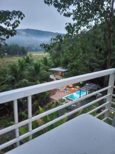 a balcony with a view of a swimming pool at JKO woodland resort in Malampay