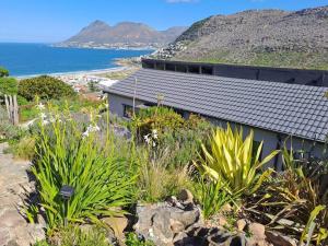 a house on a hill with a view of the ocean at Studio Apartment in Glencairn in Cape Town
