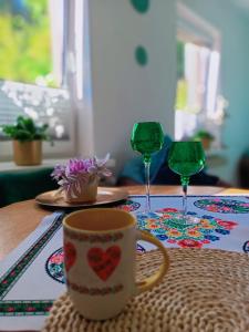 KamesznicaにあるZakątek Słoneczny pod Baranią Górąのテーブル(ワイングラス2杯、コーヒーマグカップ付)
