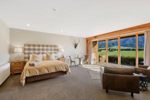 1 dormitorio con 1 cama, mesa y sillas en Hanmer High Country Views, en Hanmer Springs