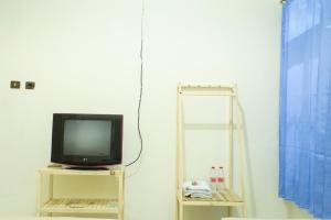 a tv sitting on a shelf next to a window at PUTRAJAYA HOTEL in Majalengka