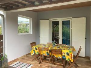 a dining room with a table and chairs at les cases prés du lac in Cilaos