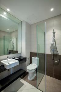 ein Bad mit einem WC, einem Waschbecken und einer Dusche in der Unterkunft Miers Kuningan, ARTOTEL Curated in Jakarta