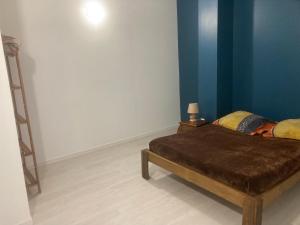 um quarto com uma cama e uma parede azul em bungalow les cases près de la Mare à joncs em Cilaos