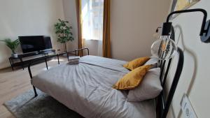 a bedroom with a bed with yellow pillows on it at ATF Apartments in Riga