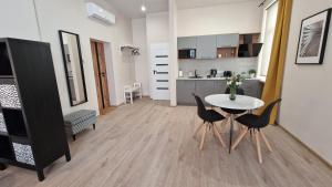 a living room with a table and chairs and a kitchen at ATF Apartments in Rīga