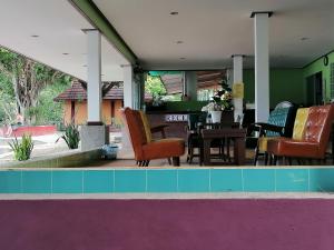 a swimming pool with chairs and a dining room at Phi Phi View Point Resort in Phi Phi Islands