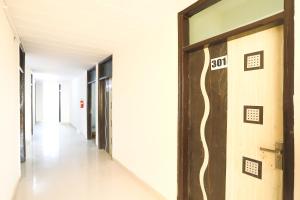 a hallway of an office building with a exit sign on the door at OYO Flagship 61722 Rajmahal Residency Hotel in Bhiwadi