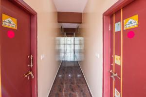 a hallway with two red doors at OYO Flagship 68124 Shangri-la Hotel in Kushālnagar