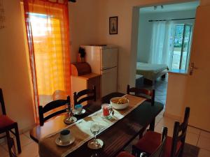 a dining room with a table and a refrigerator at Apartments Naki - free parking in Slatine