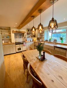 une grande cuisine avec une table et des chaises en bois dans l'établissement Cottage in the Heart of Frome, à Frome
