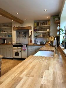 a large kitchen with wooden floors and a counter top at Cottage in the Heart of Frome in Frome