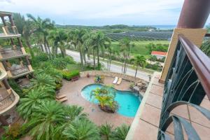 een uitzicht over een zwembad en palmbomen bij Pineapple Villa 442 condo in Roatan