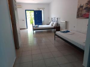LivadakiaにあるSerifos Palaceのベッド2台とソファが備わる客室です。
