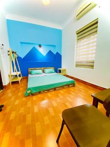 a bedroom with a bed and a blue wall at Lion Homestay in Ninh Binh