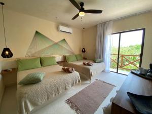 una camera con 2 letti e un ventilatore a soffitto di Sunsteps casa holbox a Isola Holbox