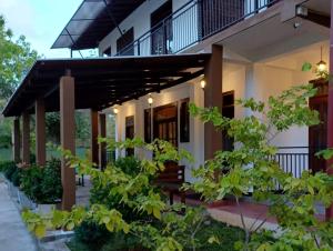 uma casa com um alpendre e uma varanda em Forest edge villa em Anuradhapura