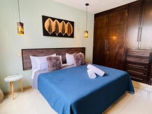Un dormitorio con una gran cama azul con almohadas en Magnolia A Luxury stay 5 minutes from Downtown, en Tepatitlán de Morelos
