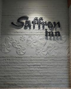 una pared con graffiti en ella con las palabras posada graffiti en Saffron Inn, Bhiwara, en Bhīlwāra