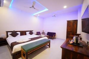 1 dormitorio con 1 cama y TV en Saffron Inn, Bhiwara, en Bhīlwāra