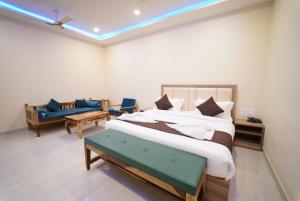 1 dormitorio con 1 cama grande y 1 sofá en Saffron Inn, Bhiwara, en Bhīlwāra