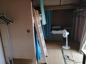 高松市にあるkaeru Guest houseの小さなお部屋で、二段ベッド1組、鏡が備わります。