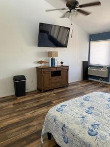 1 dormitorio con 1 cama y TV de pantalla plana en Legend oaks, en Gautier