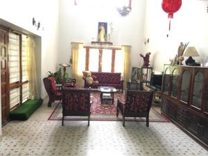 a living room with couches and a table and chairs at White Butterfly in Trivandrum