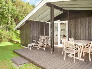 una terraza de madera con mesa y sillas. en 5 person holiday home in G rlev, en Gørlev