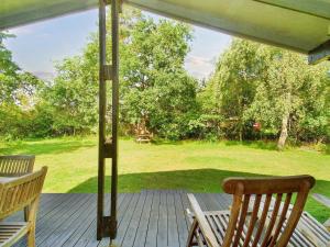 un porche con 2 sillas, una mesa y un campo en 5 person holiday home in G rlev en Gørlev